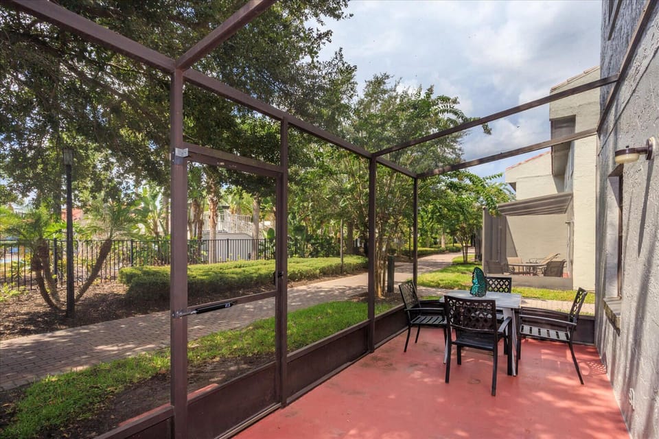 Screened patio with outdoor seating overlooking a landscaped walkway.