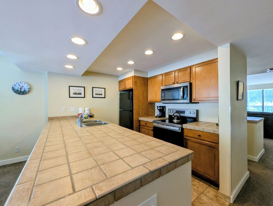 Your spacious kitchen features warm wood cabinets, tile counters, and full appliances for home-cooked meals during your stay.
