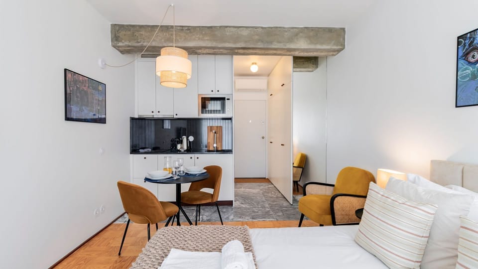 This cozy studio blends a comfortable sleeping area with a practical kitchenette and dining nook, perfect for enjoying a home-cooked meal or a morning coffee. The smart layout ensures a seamless stay, offering everything you need within easy reach.