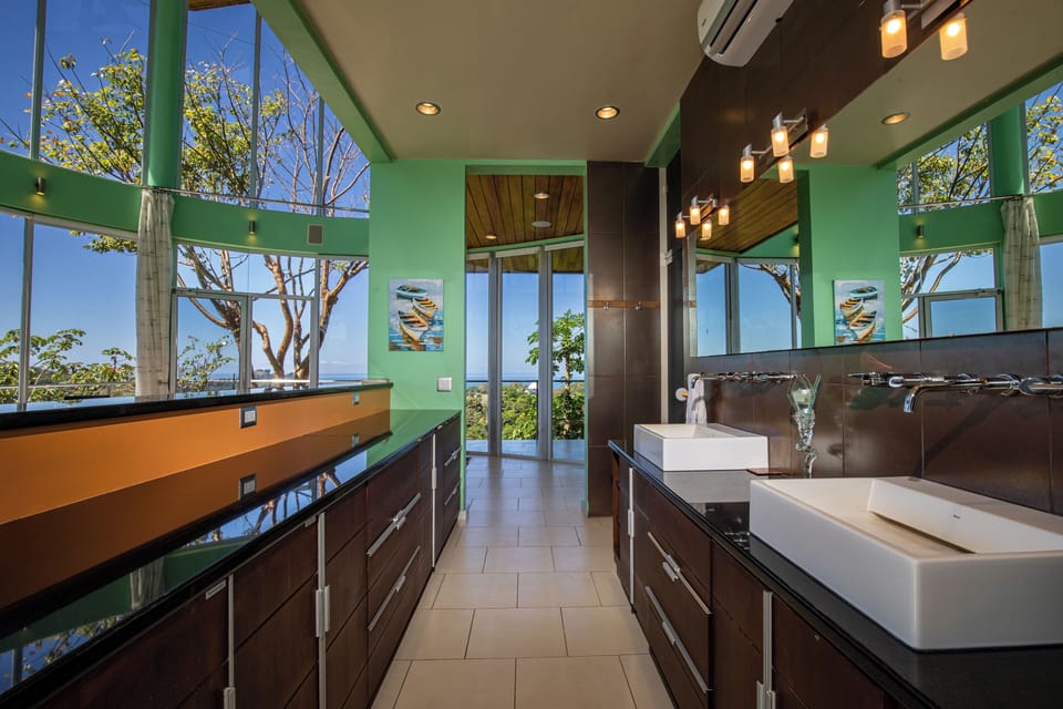 The open-concept Master Bathroom vanity reflects the rainforest view while you prepare for the day