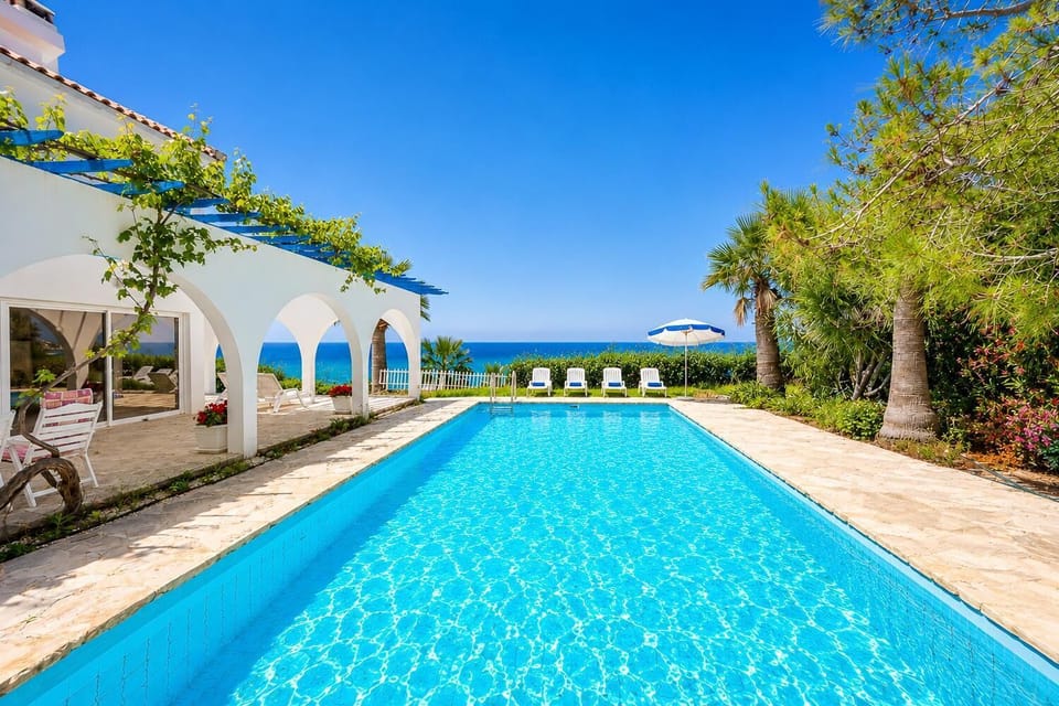 Seafront villa with a large private pool, arched terrace, and stunning Mediterranean views.