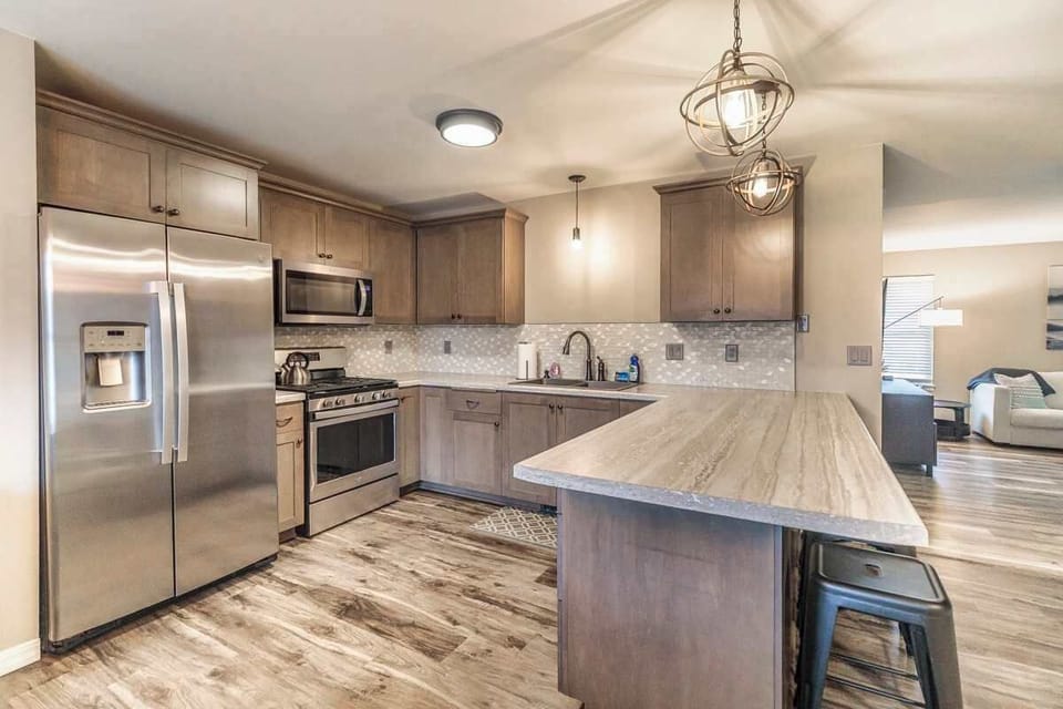 Modern kitchen featuring sleek stainless steel appliances, perfect for prepping meals or game-day snacks. Stylish, functional, and just steps from Lambeau Field—ideal for your Green Bay getaway.