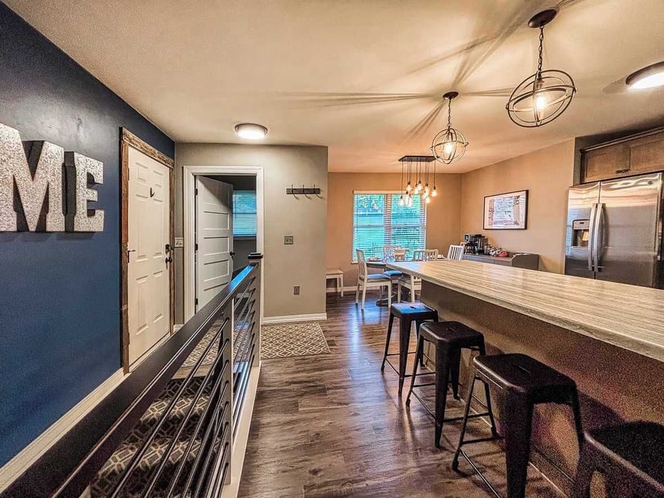 Charming decorative wall lines the hallway, leading to the kitchen’s cozy dining area, plus easy access to the half bath and laundry—combining style and convenience in one space.