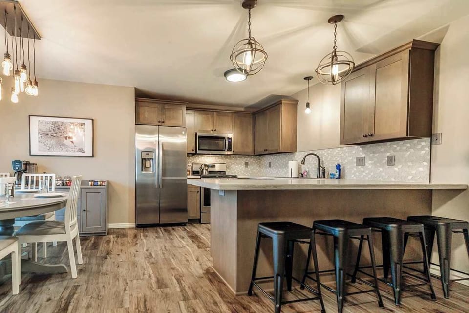 Fully stocked kitchen with all the essentials for cooking and tailgating, plus seating for all with 4 counter stools and a spacious dining table. Perfect for gathering before or after the big game—just a short walk to Lambeau Field!