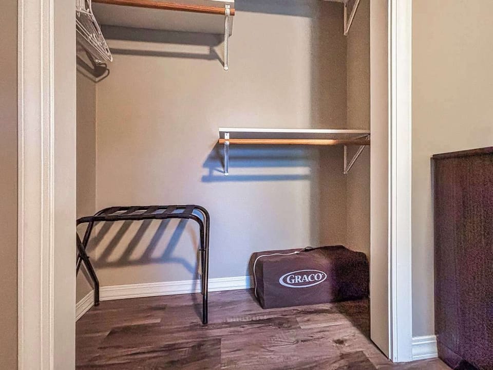 Closet neatly organized with a luggage rack and pack ’n play, providing convenient storage and essentials for your stay.