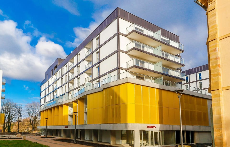 Stylish high-floor residence with bold yellow panels, offering a bright and modern base for exploring Metz.