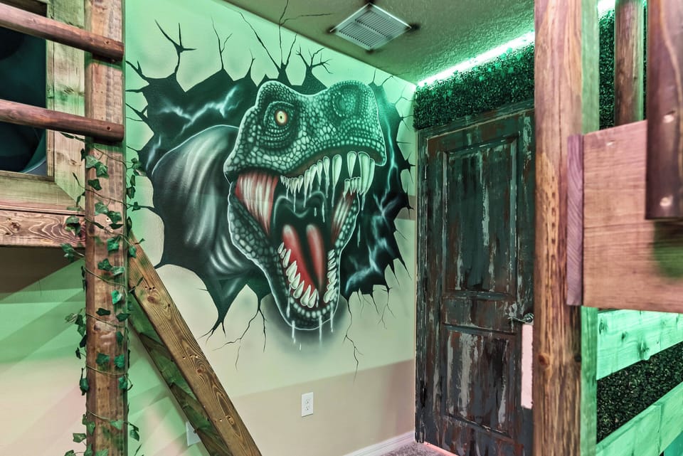 Experience a lively atmosphere with a vibrant dinosaur mural and rustic wood accents. The cozy green lighting sets a playful vibe, making it an ideal spot for guests of all ages to enjoy fun and adventure together.