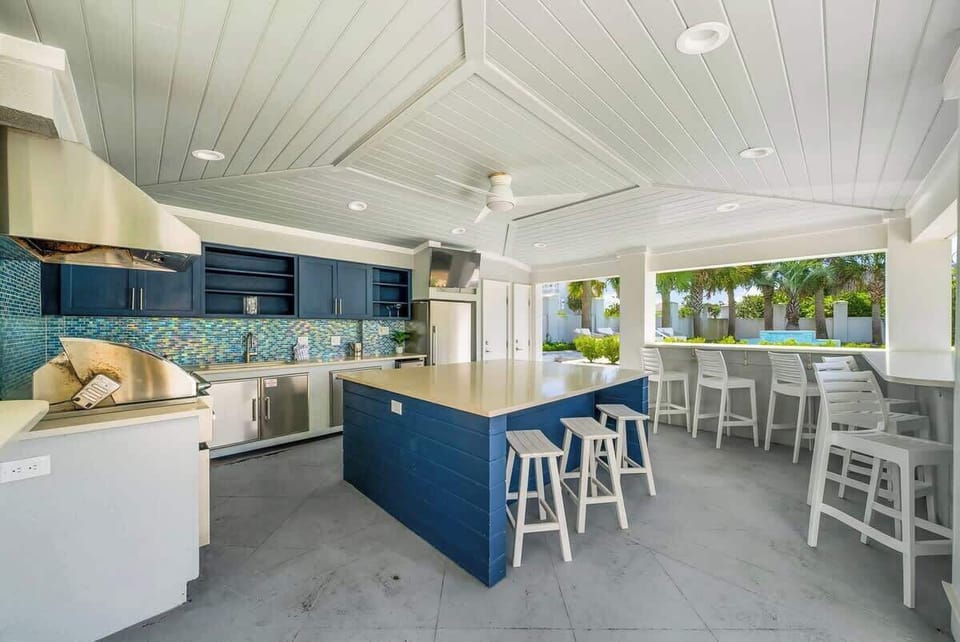 The home features an outdoor cabana with built-in grill & large island. Perfect for those poolside cookouts.
