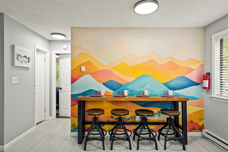 Stylish Kitchen: Bright space with modern appliances and artistic mountain mural for fun gatherings!
