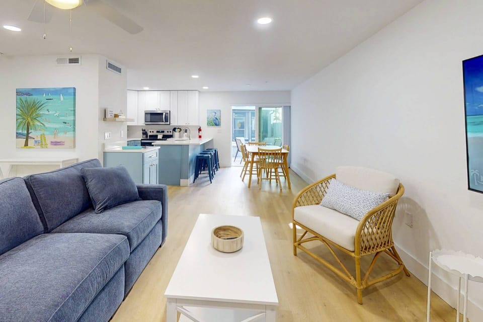 Open living room with views of the pool and outdoor spaces + Dining space for six