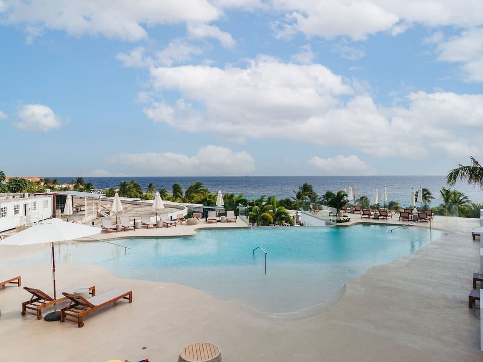 Relax by the infinity pool with stunning ocean views just steps from your suite/residence.