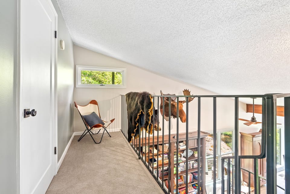 This cozy loft nook offers a quiet space to read, reflect, or simply enjoy the view overlooking the game room below. With soft natural light and a comfy chair, it’s a perfect little hideaway.