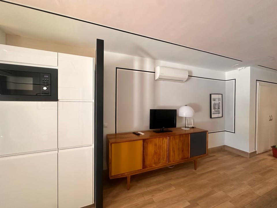Estudio diáfano con zona de descanso, zona de comedor y cocina americana