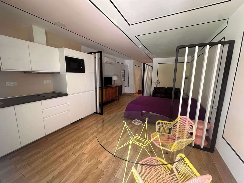 Estudio diáfano con zona de descanso, zona de comedor y cocina americana