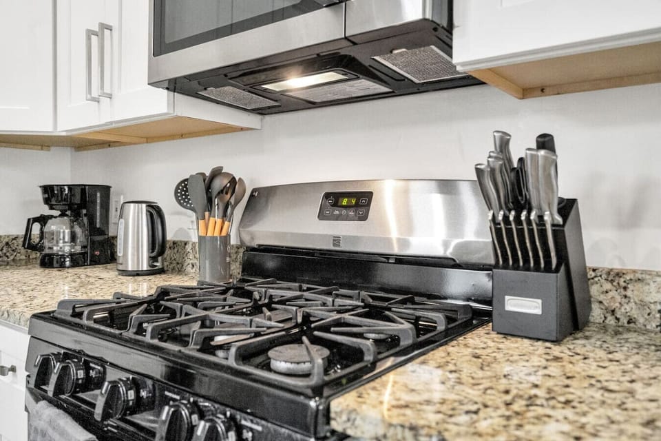 Fully-stocked kitchen with drip & Keurig coffee makers, electric kettle, blender, toaster, and stainless steel appliances (fridge, gas stove/oven, microwave, and dishwasher)