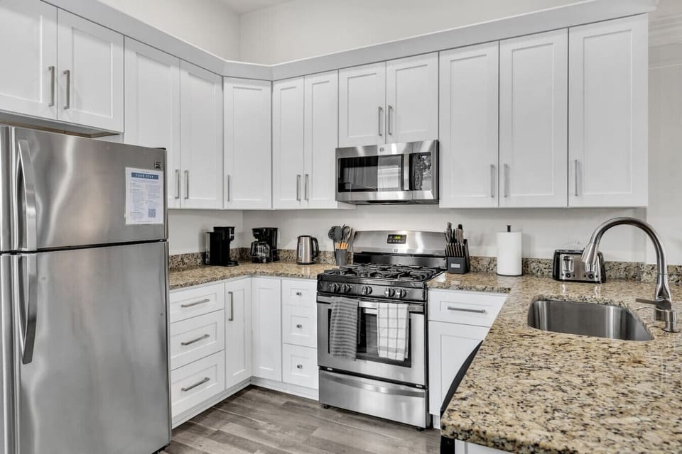 Fully-stocked kitchen with drip & Keurig coffee makers, electric kettle, blender, toaster, and stainless steel appliances (fridge, gas stove/oven, microwave, and dishwasher)
