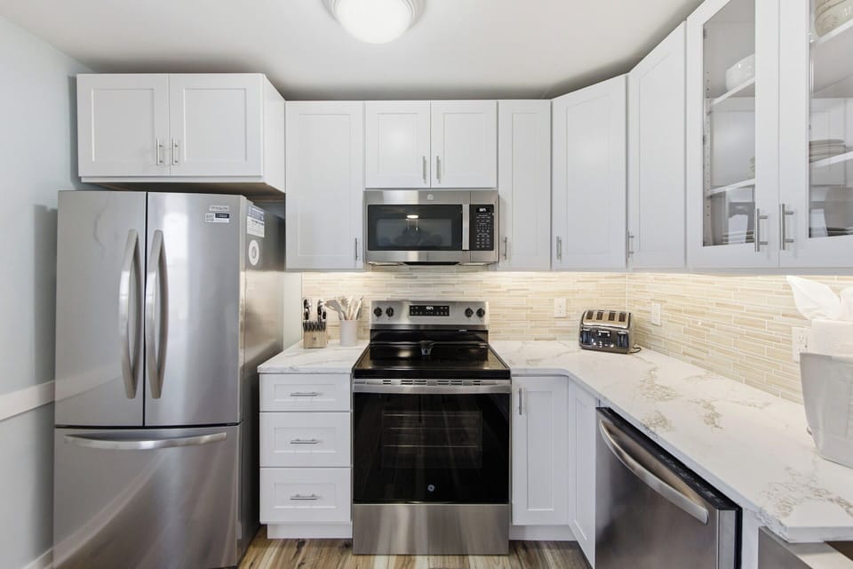 Bright modern kitchen with stainless appliances and sleek quartz counters