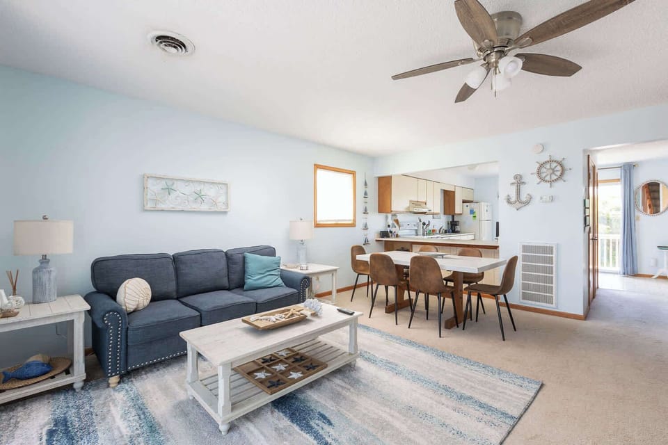 Mid Level Living Area w/ Sofa Seating, Coffee Table, and Coastal-Inspired Decor with Dining Area