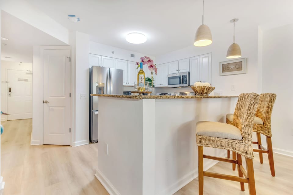 Your bright kitchen features granite counters, stainless appliances, and a breakfast bar perfect for morning coffee.