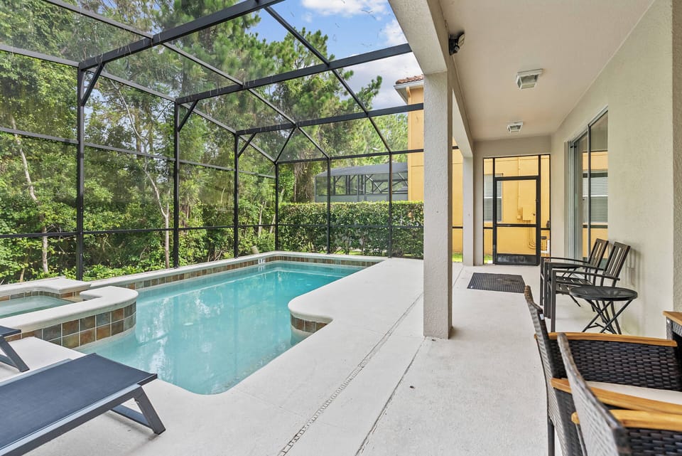 Step outside to enjoy your own private oasis, featuring a sparkling pool surrounded by lush greenery. Relax on the sleek loungers or unwind in the hot tub, all under a protective screen that allows for comfort and peace.