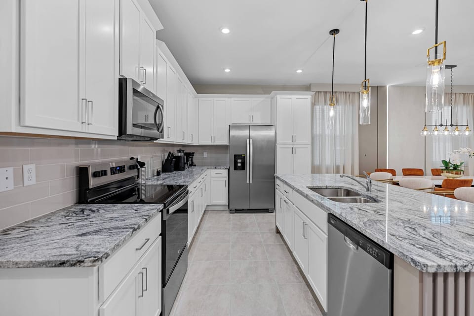 Welcome to this stylish kitchen featuring sleek white cabinetry and a beautiful marble countertop, ideal for your culinary adventures.