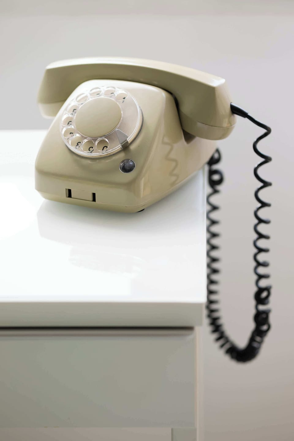 A vintage rotary telephone resting on a white table, providing a nostalgic accent in an otherwise modern interior.