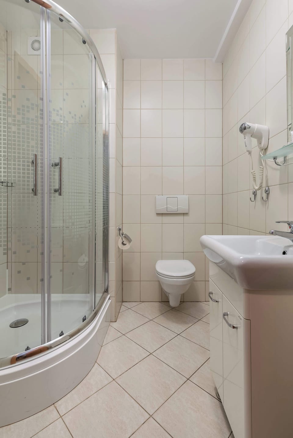 Bright and functional bathroom, where the guests can use modern shower and welcoming toiletries set.