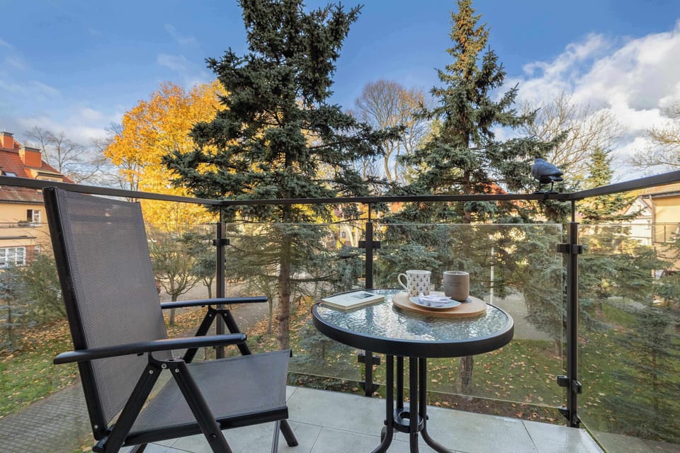 Furnished balcony with green surroundings. 