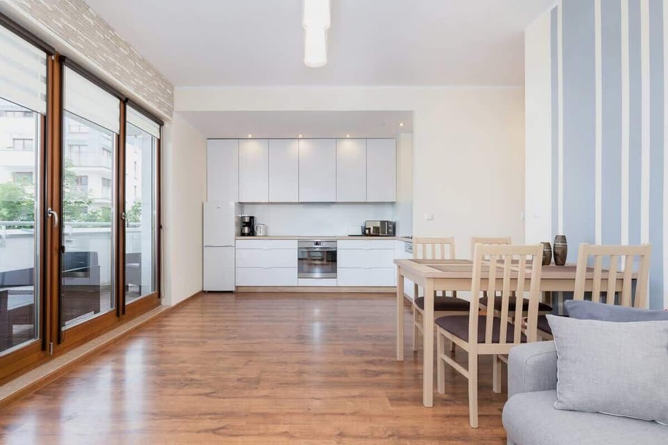Spacious living room with kitchenette. On the left you can see the door leading to the balcony. 