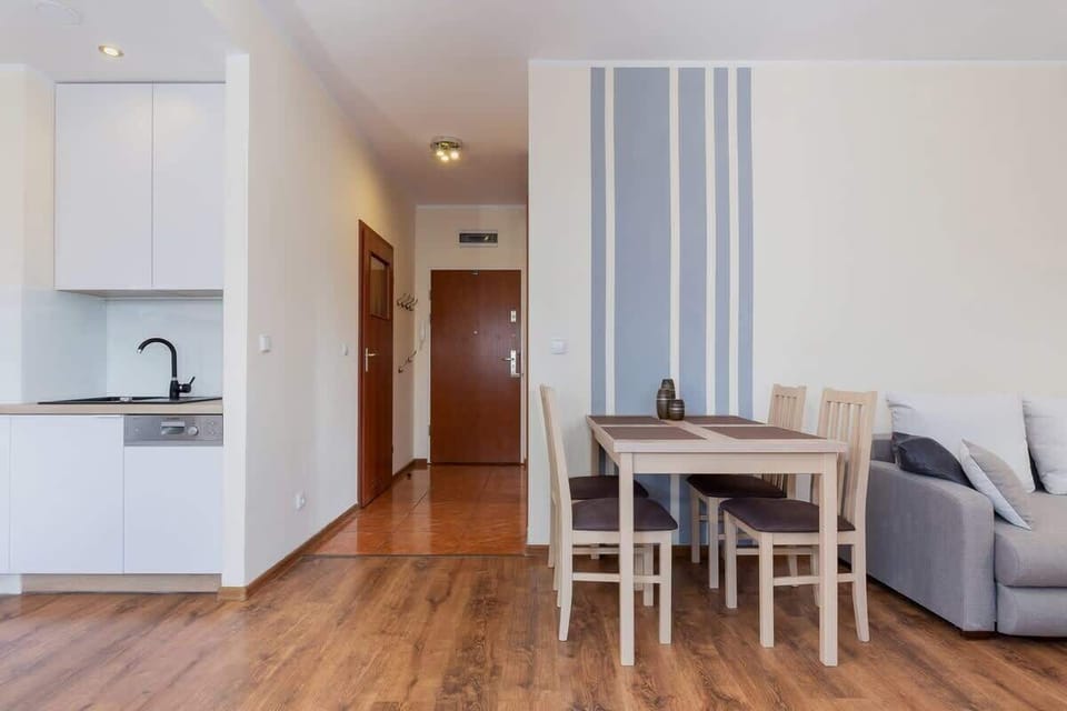 View of the entrance to the apartment on the right you can see the sofa and wooden table, and the kitchenette on the left. 