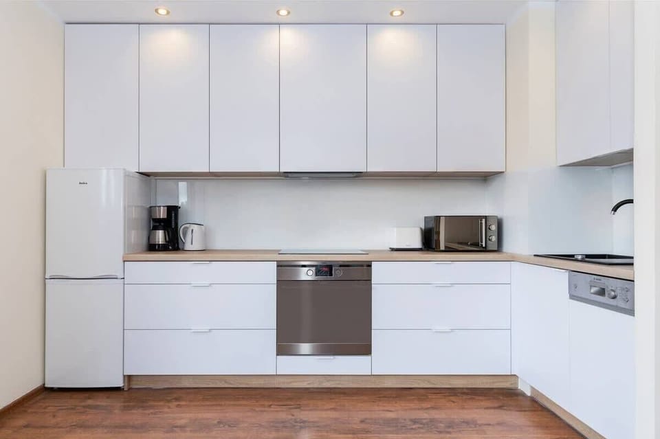 Modern kitchen with fridge with freezer, oven, coffee machine and microwave. 