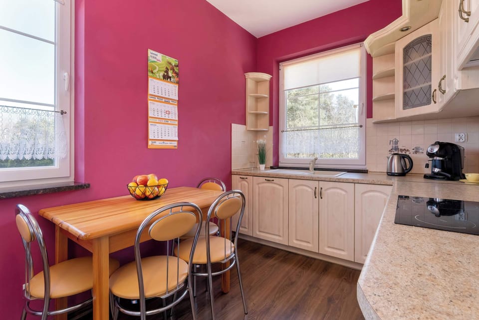Dining area and fully equipped kitchen with induction cooktop, oven, microwave, electric kettle, refrigerator with freezer and dishwasher.