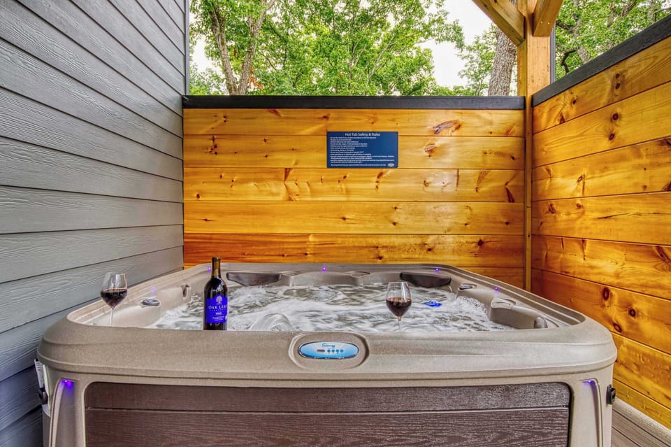 Unwind in the bubbling hot tub under string lights, sip your favorite drink, and soak in the privacy of Bearfoot Getaway's secluded back deck.