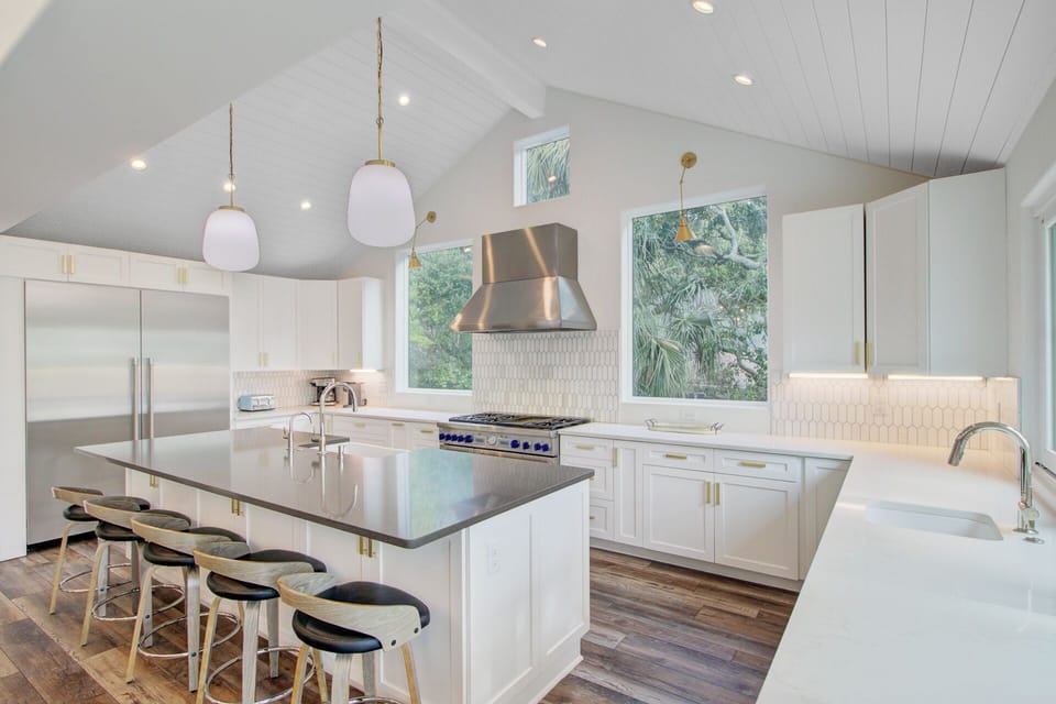 Your culinary dreams come alive in this stunning white kitchen with gleaming countertops, professional-grade appliances, and peaceful garden views.