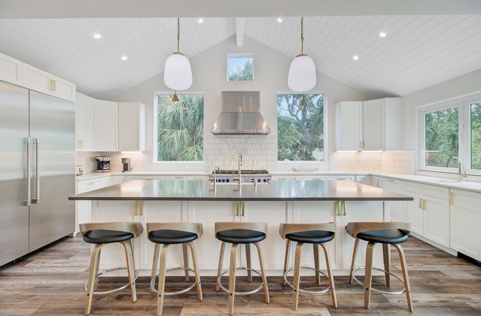 Your gourmet kitchen awaits with sleek countertops, modern appliances, and island seating where you'll savor morning coffee overlooking lush greenery.