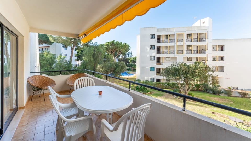 Enjoy meals outdoors with a serene green backdrop. #OutdoorDining #BalconyViews #LovelyStayPortugal #HolidayApartment