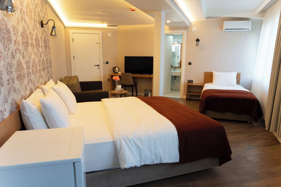 Executive Quadruple Room, Non Smoking | Minibar, in-room safe, desk, laptop workspace