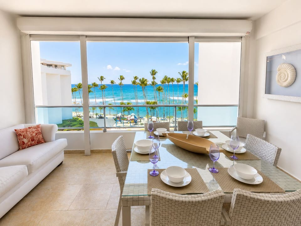 Balcony dining area with panoramic windows and stunning Caribbean Sea views.