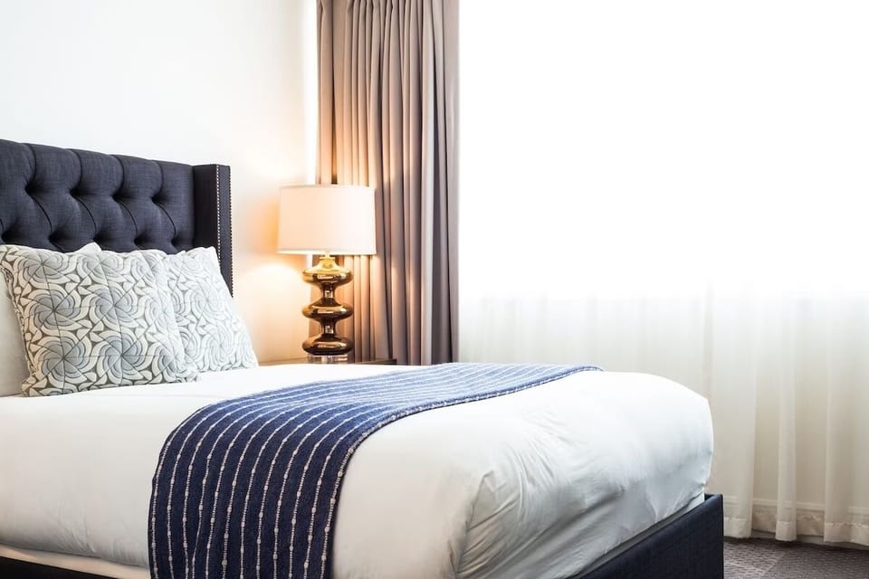 Relax into quiet comfort with crisp bedding and soft curtains.