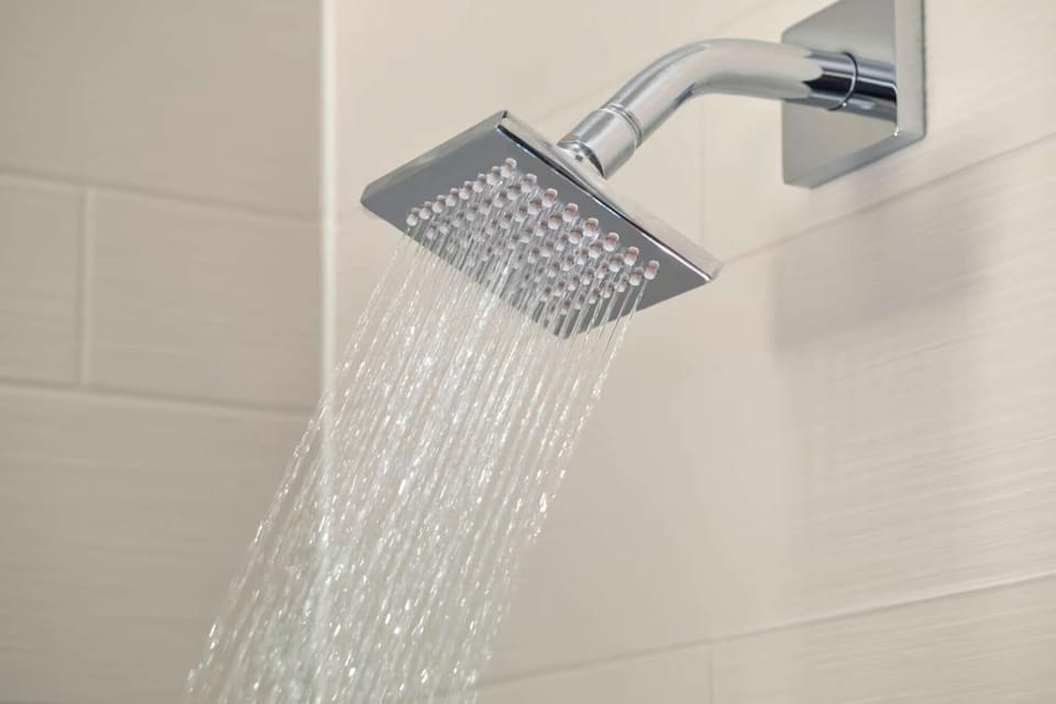 Close-up of rainfall showerhead with running water