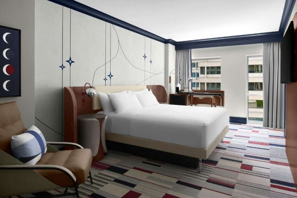 CLASSIC KING ROOM: Full room overview showing king bed, lounge armchair, workspace &amp; large window