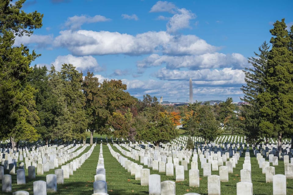 Arlington Cemetery with white headstones and DC in the distance