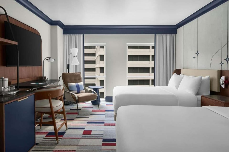 Classic Queen Room with Queen Beds: Wide view of two queen beds, lounge chair &amp; window overlooking city views