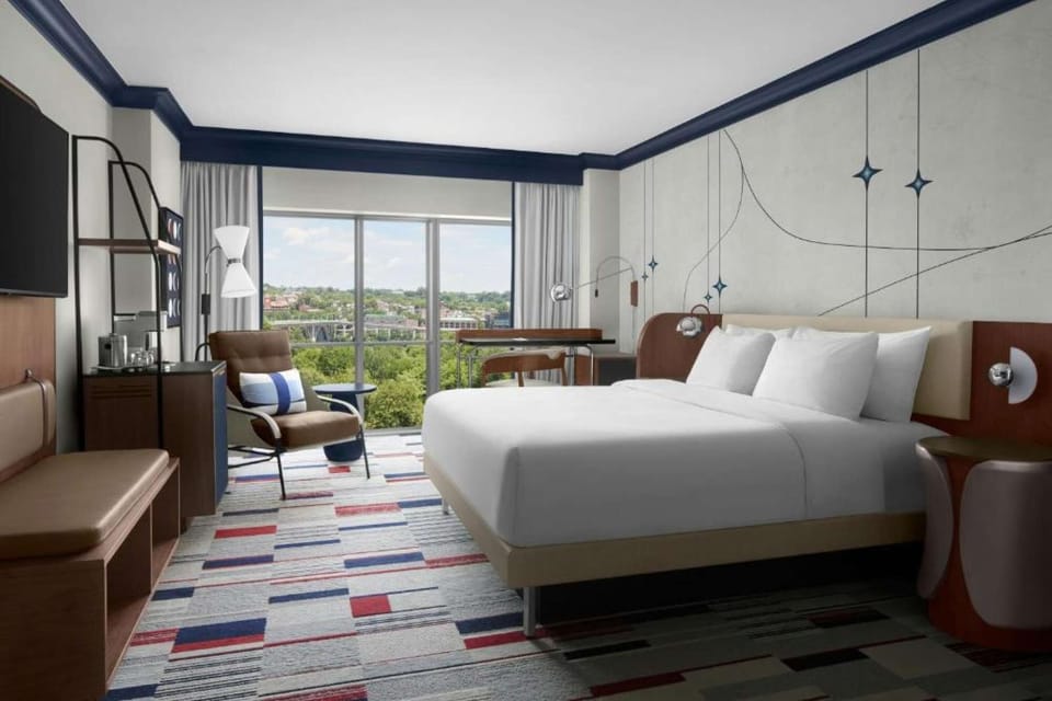 Deluxe King Room: King bed, lounge seating, workspace &amp; large window with lush treetop views