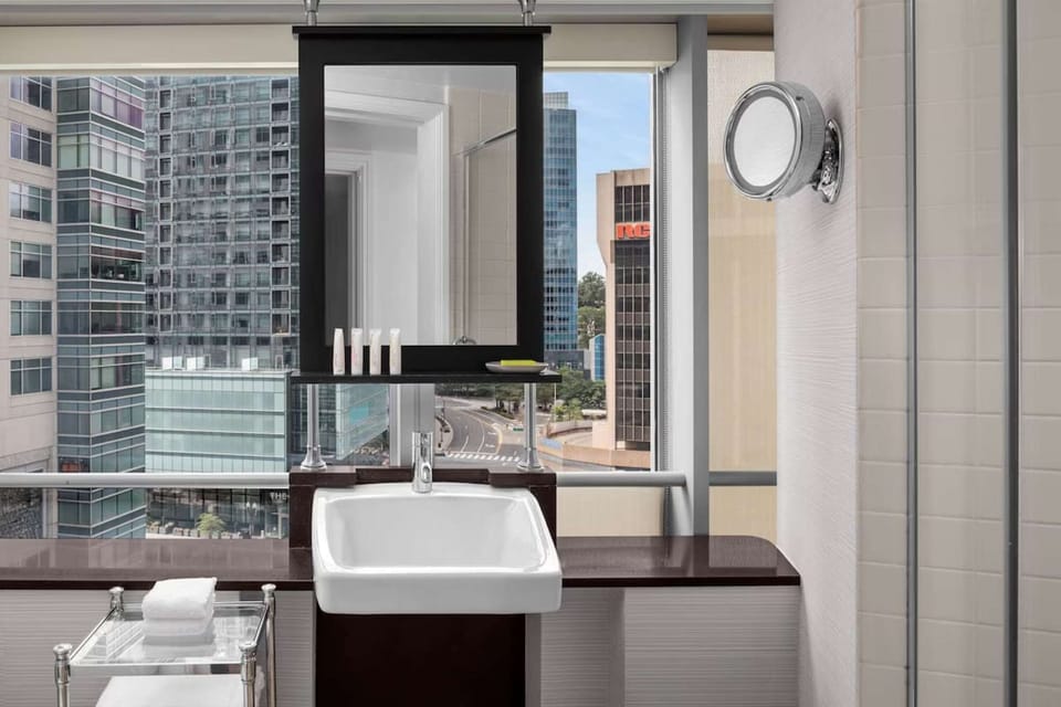 Bathroom vanity with large mirror and city view backdrop
