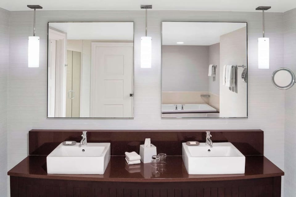 Double sink vanity with mirrors and pendant lights above