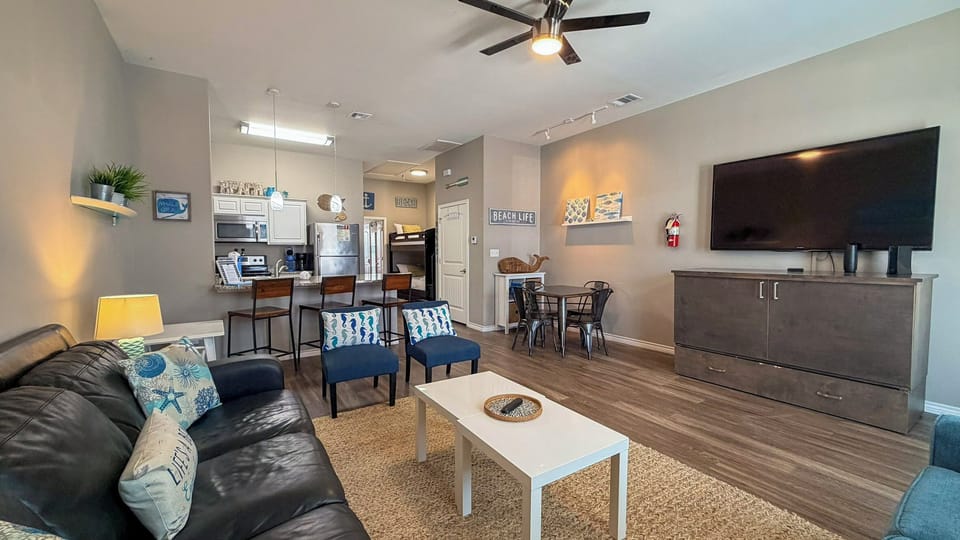 Relax in your spacious open-concept living space with comfortable seating, fully equipped kitchen, and modern entertainment center for perfect vacation moments.