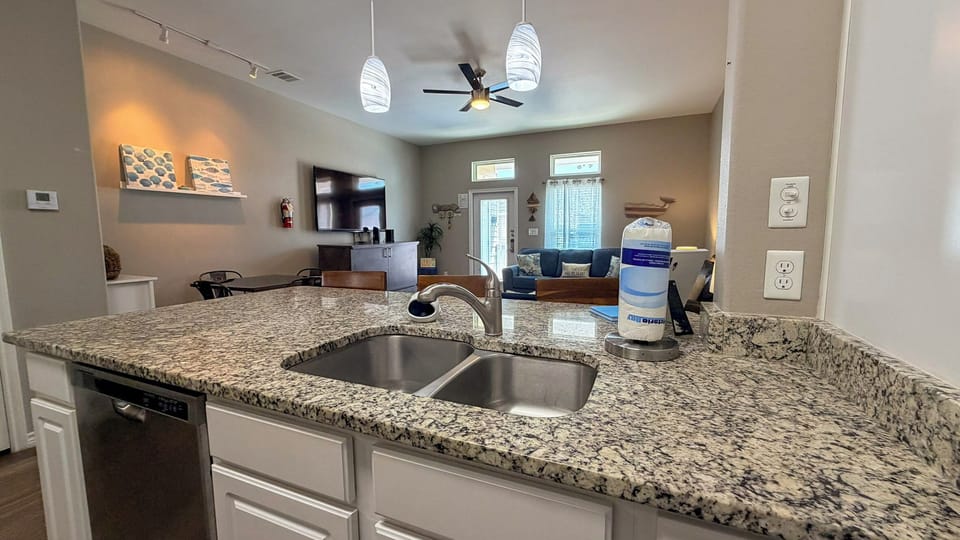 Your open kitchen flows seamlessly into the living space, featuring granite countertops and modern appliances perfect for preparing meals while staying connected.