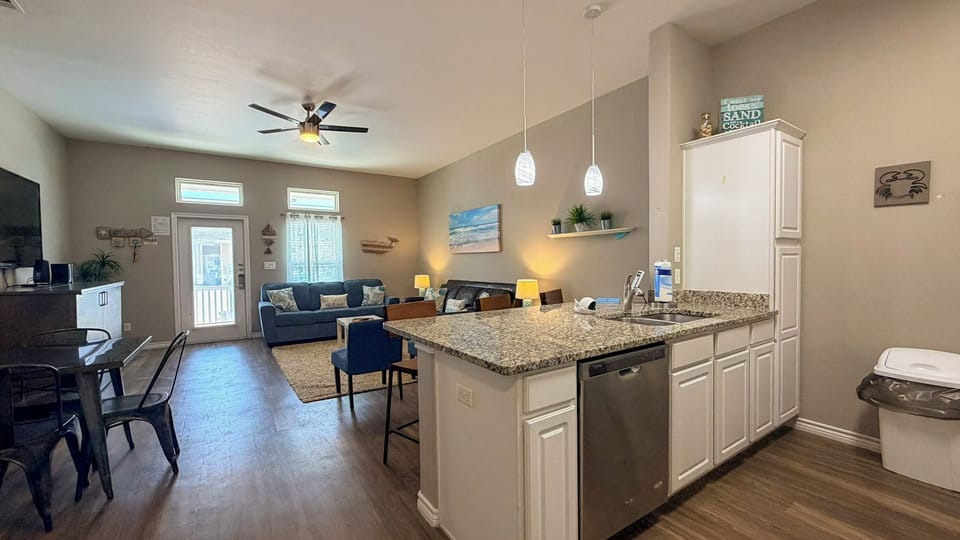 Your bright open-plan retreat blends kitchen, dining, and living seamlessly. Cook at the granite island while chatting with loved ones on plush sofas.
