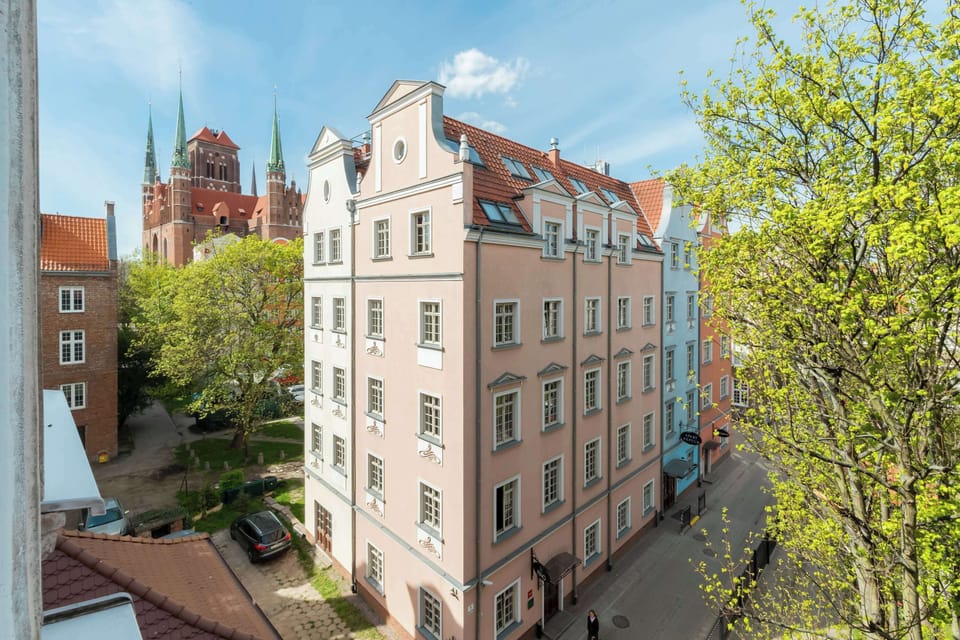 A quaint street with greenery and historic buildings highlights the neighborhood’s character.